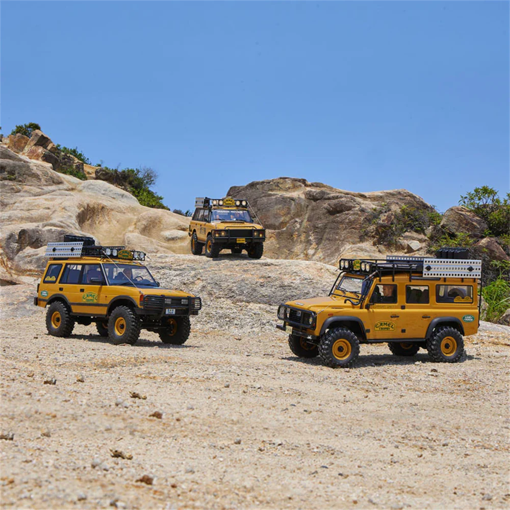 FMS FCX10 Land Rover Discovery RC Crawler grouped with other Camel Trophy models on rocky terrain